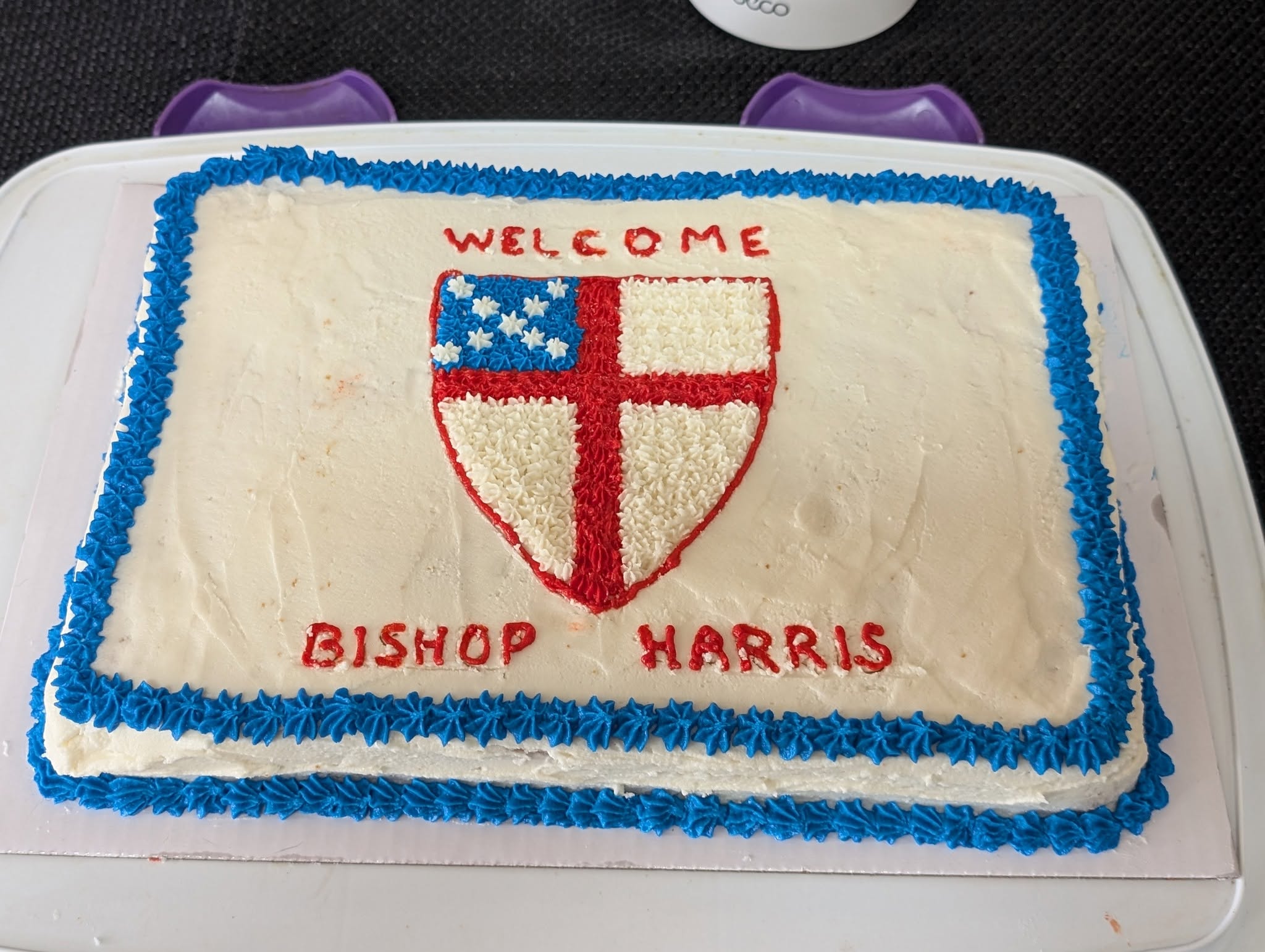 A celebration cake welcomes Bishop Harris with the Episcopal shield.