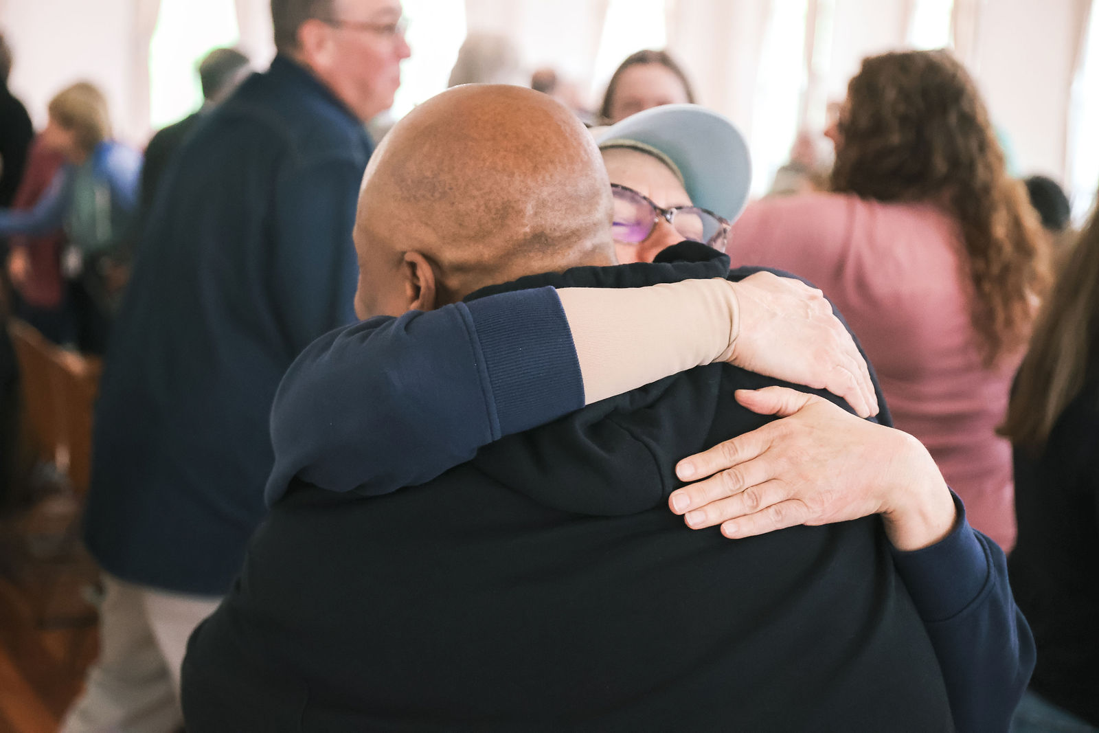Clergy greeting one another with an embrace during the Spring Clergy Retreat