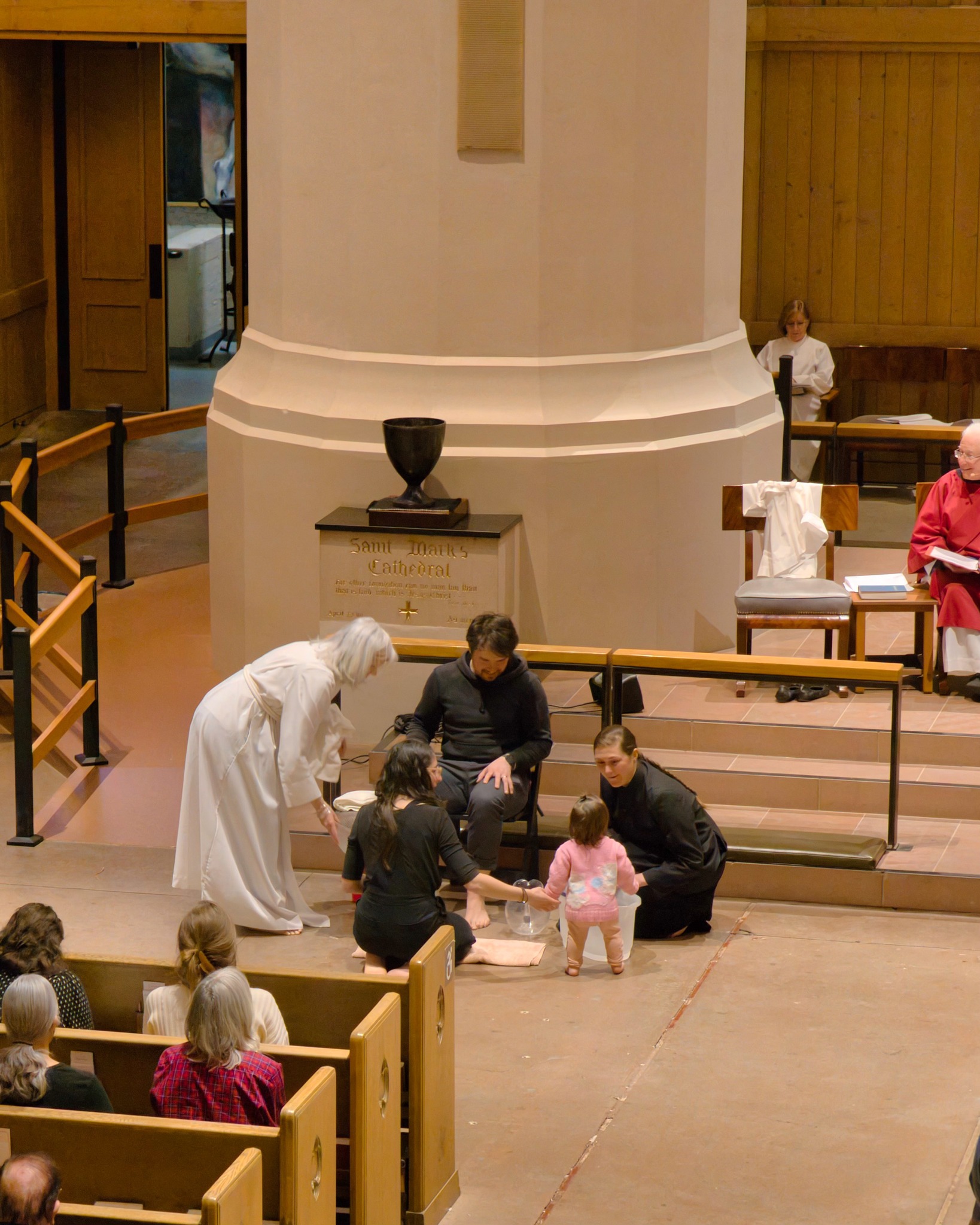 Children and adults gather near the front of a church during an intergenerational worship practice.