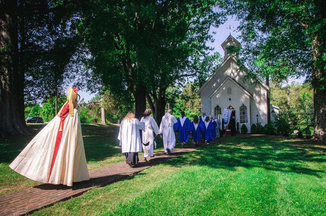 Bishop Stevenson and clergy process with the Grace Episcopal Church congregation toward the church.