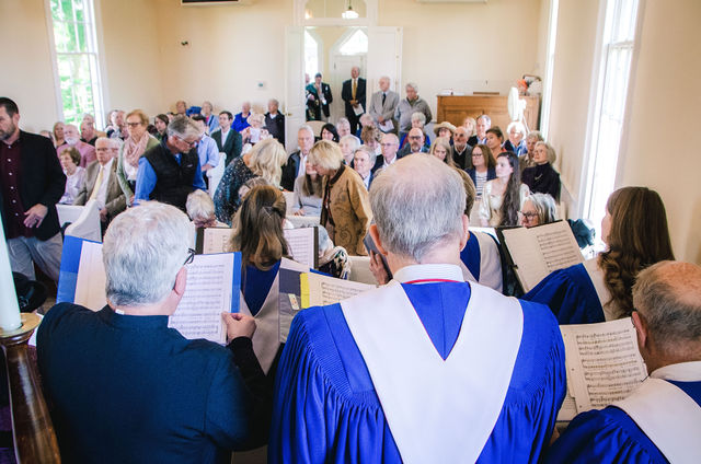 The Grace Episcopal Church sanctuary filled with clergy, choir, and congregants during the anniversary service.