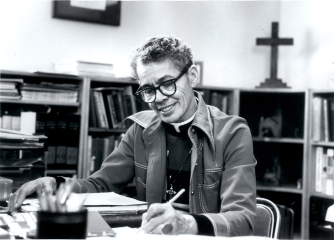 The Rev. Dr. Pauli Murray seated at a desk.