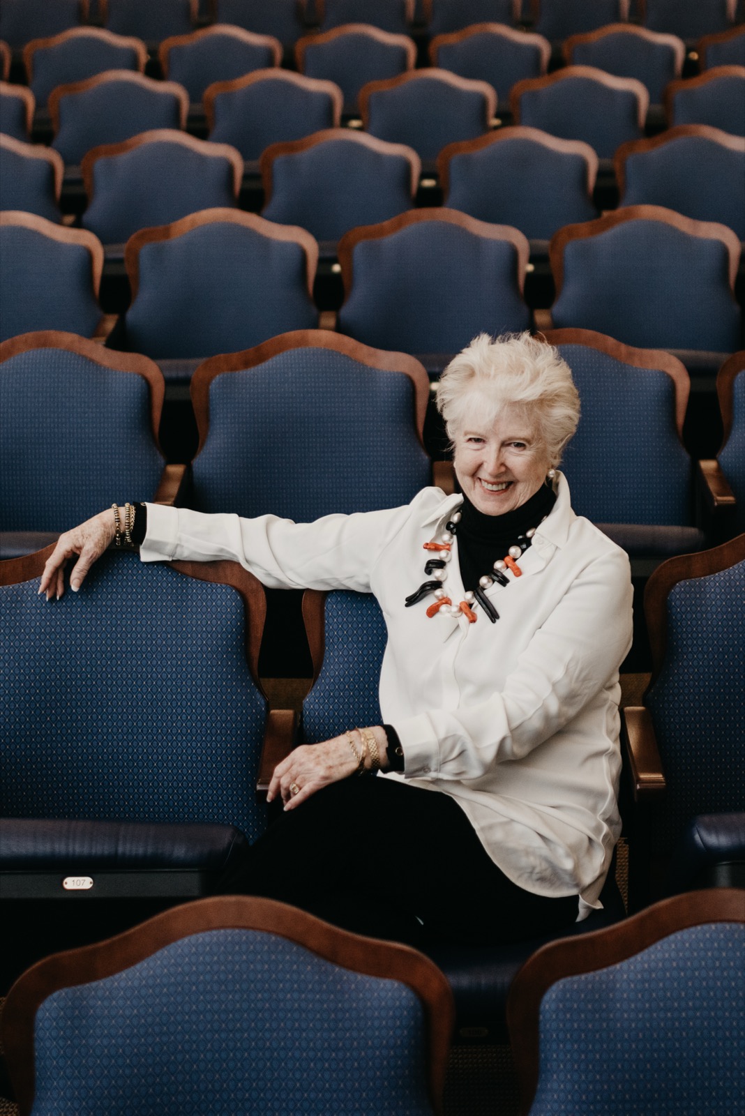 The Rev. Dr. Vienna Anderson seated among rows of blue chairs.
